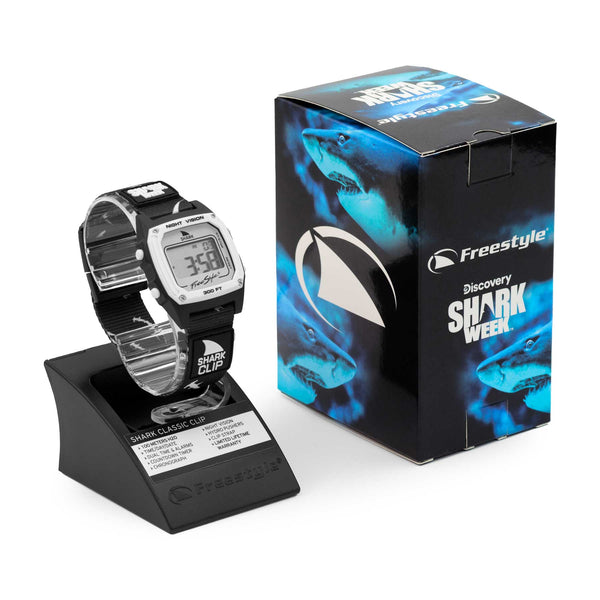 Freestyle SHARK CLASSIC CLIP SHARK WEEK MEGA HAMMERHEAD watch positioned next to its box and display stand.